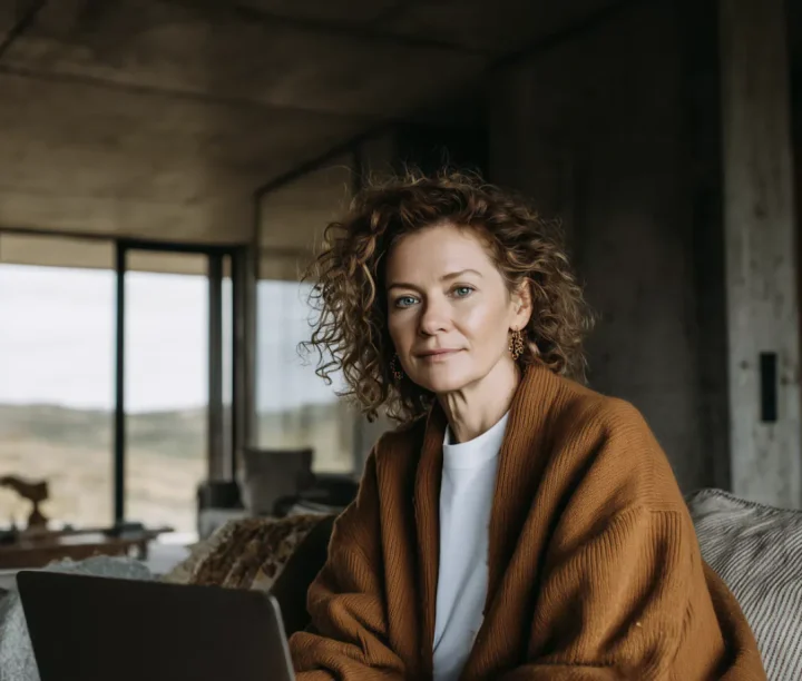Woman wrapped in a blanket sitting calmly by a window